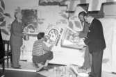 Konstnärerna Sigfid Carlsson (till vänster) och Kurt Dejmo (sittande på huk) arrangerar utställning på Konstföreningen i Uddevalla i april 1947. Nils Asp till höger (pekande med penna), teckningslärare och konstnär.
