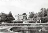 Gunnebo slott i Mölndal på ett vykort från 1900-talets mitt. I förgrunden syns den runda dammen och ovanför en terrass med klippta formationer av lind s.k. boskéer.