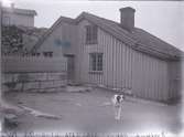 Det så kallade Rundbergska huset på Banviksgatan, en hund går över gårdsplanen framför huset i riktning mot betraktaren