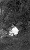 Kvinna med katt i skogsbacke