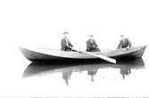 Tre män i en roddbåt, Gustav Andersson längst till höger.