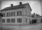 Man utanför Kryddgårdsgatan 26 (Källgatan 3), Enköping, vy från öster, sannolikt tidigast 1914