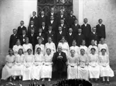 Konfirmandgrupp vid Simtuna kyrka, Uppland, troligen 2 juli 1917.  I mitten kyrkoherde August Hylander (1852-1935).