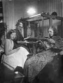 Kvinnorna i familjen Hansson väver, syr och läser i köket år 1932.
