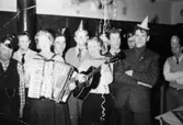 Festklädda elever och personal i manliga arbetshemmet på Stretereds skolhem, nyårsafton 1959.
 I förgrunden kvinnor med dragspel och gitarr. Med på bild fr.v. Åke Magnusson.