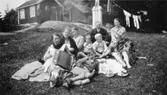 Kaffestund på gräsmattan i Kållered, 1929-1950-tal. Överst; Frans och Vega, under dem barnen Carl-Uno, Lennart, Sonja och Sture. Helga med dragspelet. Bakom henne sitter Maria och Valborg Magnusson.