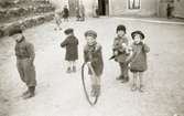 Bosgårdens barnträdgård 1939. Leif, Lille Göte, Göte med tunnband, Kicka och Mona leker utomhus.