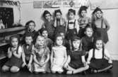 Bosgårdens barnträdgård 1938-1945. Barn som står uppställda inomhus. Alla har på sig likadana mössor som fröken hade sytt.
