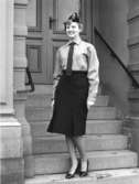 Vinteruniform för kvinnlig postiljon. Foton 4/2 1960.  Modell är Maud Bergström, bankavdelningen. Utan kavaj. Med högklackade skor.