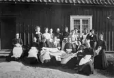 Vykortsupplaga av symöte med missionen (Kållereds missionsförsamling) vid Olas stuga, 1900-tal. I främre raden längst till höger sitter Maria Eriksson (moster till Valdeborg Johansson). Till vänster om henne (fosterbarnet och flickan) Märta Persson. Text på fotots baksida: Symöte m. missionen. Ur Valdeborg Johanssons fotoalbum.