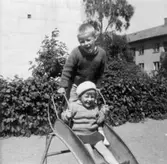 Barnen Torbjörn och Carina vid en rutschkana på Brunnsgatan, 1965. Barnen är syskon samt Dahlbjörks barnbarn.