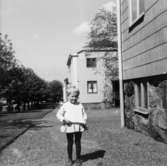 En liten flicka som står utanför papyrushusen på Brunnsgatan (1-9). 1960-tal.