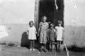 Fyra flickor står uppställda utanför en trappuppgång på Bragegatan, 1938-1939. Från vänster; Siv, systern Anne-Marie (gift Lindholm), Vanda F, ?. Anne-Marie är mor till givaren.