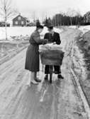 Lantbrevbärare, postiljon Erik Bergman (cykelåkande) i
Delsbo. April 1956.

Brevbäringsturen är 2 ½ mil lång och omfattar nästan 300 hushåll. Postväskan väger ofta 30-40 kg.