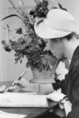 Uppvaktning å postsparbankschefens Sven Lönnqvist tjänsterum.  Foto
10/3 1959.  Fru Vanhala, Finland, skriver sitt namn i gästboken.