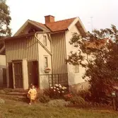 En kvinna sitter på trappan till bostadshuset Roten F25, Trädgården. År 1972.