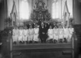 Ett konfirmationsfoto av givaren 
Lilly Nygrens 14-åriga syster Signe Andreasson (gift Haverström) som sitter i nedre raden till höger.
Den vithårige mannen är konfirmationspräst/rektor Ludvig Hallgren. Fässbergs kyrka 1922.