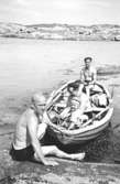 I familjen Garthmans eka vid Näset. Till vänster: Charlie Magnusson. I båten Alf Garthman, fadern Helmer och Arne Jansson. 1950-tal.