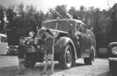 Bröderna Alf och Leif Garthman står vid en brandbil på Heden i Göteborg, 1953-54.
