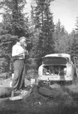 Elon Sävström (slöjdlärare på Sörgårdsskolan) och vännen Helmer Garthman (ej i bild) på väg till Norge för fiskesemester med Elons bil, en Borgward Isabella. Här är det paus i Värmland. 1960-tal. Skänkt av sonen Alf Garthman som arbetade många år på Mölndals stadsmuseum.