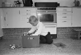 Pontus sitter på köksgolvet och letar runt i en plastback som är fylld med duplo-lego. En byggplatta och ett par duplo-bilar ligger på golvet. Hoppetossan, Katrinebergs daghem, 1992.