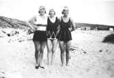 Tre unga kvinnor på en sandstrand, 1920-tal