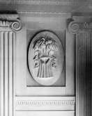 I en tablett, en stående oval relief med emblemet 