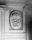 I en tablett, en stående oval relief med emblemet 