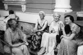 Tre kvinnor sitter på en trappa och en kvinna sitter i en stol mittemot dem. Gunnebo slott, 1937.