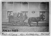 Postdiligens på linjen Lidköping - Hjo, 1860-talet.  Postiljon
Magnusson på kuskbocken framför postkontoret i Hjo.  Enda kända
bilden av svensk hästdiligens i trafik.   (Se även reproneg. 92.C,
67.D och 97.E)