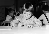 En flicka som ritar vid Holtermanska daghemmet 1953.