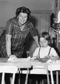 En lärarinna och en flicka vid ett bord. Holtermanska daghemmet 1953.