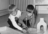Två pojkar leker med byggklossar på golvet vid Holtermanska daghemmet 1953.