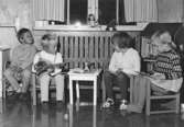 Fyra barn som sitter på barnmöbler vid Holtermanska daghemmet 1953.