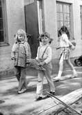 Tre flickor promenerar på gårdsplanen utanför huset. Holtermanska daghemmet juni 1973.