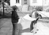 Två barn som skakar ett ljust tygstycke utanför Holtermanska daghemmet juni 1973.