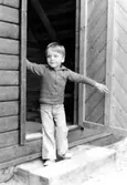 En pojke som står i ingången till ett förrådshus. Holtermanska daghemmet 1973.