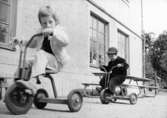Två pojkar som cyklar på trehjulingar. Holtermanska daghemmet juni 1974.