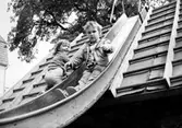 Två barn i en rutschbana. Holtermanska daghemmet juni 1974.