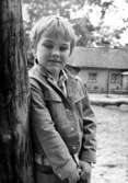 En pojke som lutar sig mot en trädstam. Holtermanska daghemmet juni 1974.