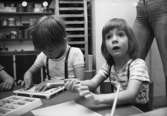 Två barn som pysslar. Holtermanska daghemmet maj 1975.