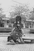 Ungdomar runt skulpturen Albert på Mölndals torg. Mölndalsbro i dag - ett skolpedagogiskt dokumentationsprojekt på Mölndals museum under oktober 1996. 1996_1024-1041 är gjorda av högstadieelever från Kvarnbyskolan 9C, grupp 1. Se även 1996_0913-0940, gruppbilder på klasserna 1996_1382-1405 samt bilder från den färdiga utställningen 1996_1358-1381.