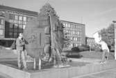 Ungdomar vid vattenskulpturen framför stadshuset. Mölndalsbro i dag - ett skolpedagogiskt dokumentationsprojekt på Mölndals museum under oktober 1996. 1996_1042-1051 är gjorda av högstadieelever från Kvarnbyskolan 9C, grupp 2. Se även 1996_0913-0940, gruppbilder på klasserna 1996_1382-1405 samt bilder från den färdiga utställningen 1996_1358-1381.