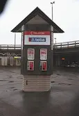 Telias telefonautomater vid Broplatsens ändhållplats för buss och spårvagn. I bakgrunden skymtar Pressbyrån. Mölndalsbro i dag - ett skolpedagogiskt dokumentationsprojekt på Mölndals museum under oktober 1996. 1996_1153-1171 är gjorda av högstadieelever från Kvarnbyskolan 9D, grupp 2. Se även 1996_0913-0940.