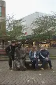 Tre ungdomar vid skulpturen Albert på Mölndals torg. Mölndalsbro i dag - ett skolpedagogiskt dokumentationsprojekt på Mölndals museum under oktober 1996. 1996_1190-1211 är gjorda av högstadieelever från Kvarnbyskolan 9D, grupp 4. Se även 1996_0913-0940.