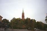 Fässbergs kyrka. Restaurang/café/konditori Sahlins terrass på Storgatan skymtar till vänster. Mölndalsbro i dag - ett skolpedagogiskt dokumentationsprojekt på Mölndals museum under oktober 1996. 1996_1338-1356 är gjorda av högstadieelever från Åbyskolan 8A, grupp 6. Se även 1996_0913-0940, gruppbilder på klasserna 1996_1382-1405 och bilder från den färdiga utställningen 1996_1358-1381.