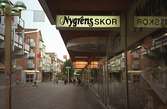 Nygrens skor på Brogatan. Mölndalsbro i dag - ett skolpedagogiskt dokumentationsprojekt på Mölndals museum under oktober 1996. 1996_1338-1356 är gjorda av högstadieelever från Åbyskolan 8A, grupp 6. Se även 1996_0913-0940, gruppbilder på klasserna 1996_1382-1405 och bilder från den färdiga utställningen 1996_1358-1381.