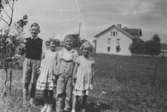 Kompisar hos familjen Elisabet och Oskar Andersson på Bergmansgatan 8, 1935. Från vänster: Rolf, Lill, Åke och Ingegärd Magnusson. I bakgrunden ses Karlsberg på Knutsegatan 15. På denna plats ligger numera Mölndals stadshus.