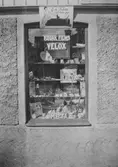 Skyltfönster med reklam för Kodaks film, Metatabletter osv. E. & K. Karlssons järnhandel, Kungsbackavägen 6, 1920-tal.