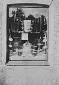 Skyltfönster med kastruller och andra köksredskap. E. & K. Karlssons järnhandel, 1920-tal.